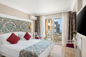 a hotel room with a bed and a balcony at Alaiye Kleopatra Hotel in Alanya