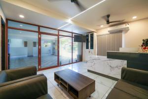 a living room with a table and a kitchen at Open Hotel by Olive - Sea Heights in Kākināda