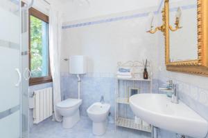 a bathroom with a sink and a toilet and a mirror at Berto's house tra mare e laguna in Cavallino-Treporti +32 photos
