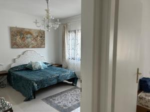 a bedroom with a bed and a chandelier at Berto's house tra mare e laguna in Cavallino-Treporti