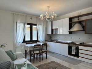 a kitchen with white cabinets and a table with chairs at Berto's house tra mare e laguna in Cavallino-Treporti