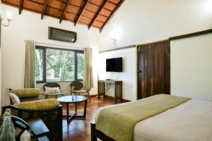 a bedroom with a bed and a living room at Kadkani River Resort Coorg in Siddapur