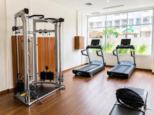 a gym with three tread machines in a room at Loft Privato, Jakarta in Jakarta