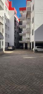 a parking lot with two cars parked in front of a building at Tulia Stays in Mtwapa