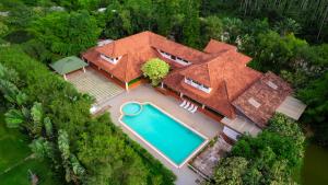 an overhead view of a house with a swimming pool at Kadkani River Resort Coorg in Siddapur