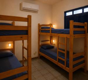 a room with three bunk beds and a window at Armorial Hostel in João Pessoa