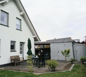a backyard patio with a table and a garage at Ferienwohnung Auszeit mit Waldgeflüster 35231 in Hesel