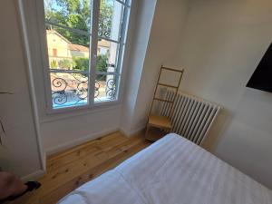 a bedroom with a bed and a large window at Villa Aestival in Saint-Symphorien