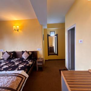 a hotel room with a bed and a mirror at Hotel Aman in Nārkanda
