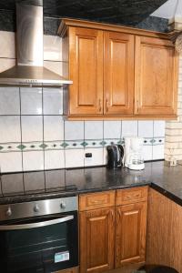 a kitchen with wooden cabinets and a stove top oven at Villa Ferra in Virovitica