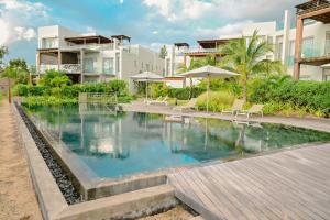 a swimming pool in front of a building at Ocean Point Beachfront Penthouses by Gerards & Angel in Pointe aux Piments