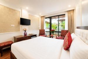 a hotel room with a bed and a desk and chairs at Golden Sail Hotel & Travel in Hanoi +19 photos