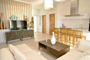 a living room with a couch and a table at Ocean Point Beachfront Penthouses by Gerards & Angel in Pointe aux Piments