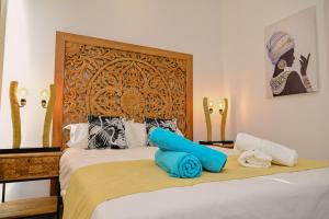 a bedroom with a bed with blue pillows on it at Ocean Point Beachfront Penthouses by Gerards & Angel in Pointe aux Piments +91 photos