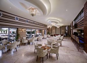 a restaurant with tables and chairs in a room at Alaiye Kleopatra Hotel in Alanya
