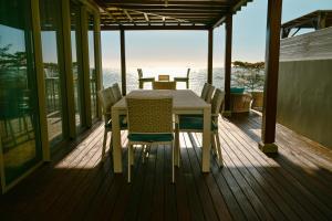 a table and chairs on the deck of a house at Ocean Point Beachfront Penthouses by Gerards & Angel in Pointe aux Piments