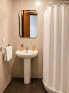 a bathroom with a sink and a shower curtain at El jardín de Cirueña in Cirueña