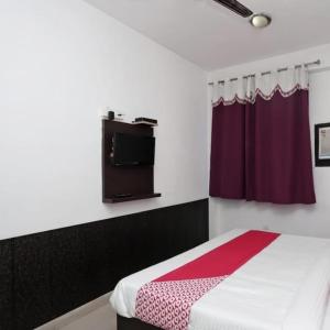 a bedroom with a bed and a tv on the wall at Taj wonder inn in Tājganj