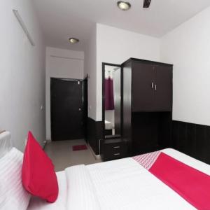 a bedroom with a white bed with red pillows and cabinets at Taj wonder inn in Tājganj