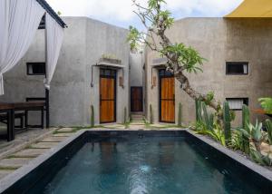 a house with a swimming pool in front of it at Iron Wave Uluwatu in Bingin Beach