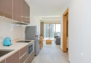 a kitchen with a refrigerator and a living room at Axis Residences By The Team in Phnom Penh
