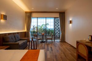 a hotel room with a bed and a table and chairs at Stadion Residences in Phumĭ Prêk Chrey