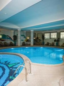 a large swimming pool in a hotel at Grand Tien Shan Hotel in Almaty