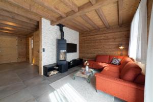 a living room with a red couch and a fireplace at Chalet Schibenstoll - Luxury & Bergblick in Wildhaus