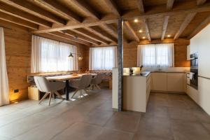 a kitchen and dining room with a table and chairs at Chalet Schibenstoll - Luxury & Bergblick in Wildhaus