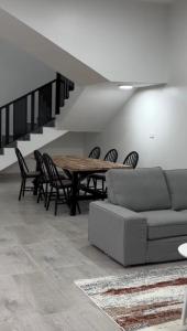 a living room with a couch and a table and chairs at دوحة ظُفار للعقارات in Sumhuran
