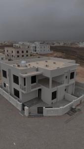 a large white building with a lot of windows at دوحة ظُفار للعقارات in Sumhuran
