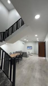 a room with a table and chairs and a staircase at دوحة ظُفار للعقارات in Sumhuran