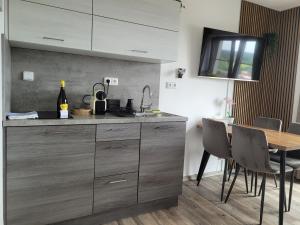 a kitchen with a sink and a table with chairs at Apartmán Kovadlina 5 - Kovářov, výhled na Lipno in Frymburk +18 photos
