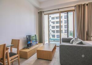 a living room with a couch and a large window at Axis Residences By The Team in Phnom Penh
