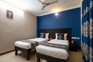 two beds in a room with blue walls at FabHotel City Inn in Hyderabad