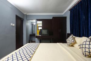 a bedroom with a bed and a tv in it at FabHotel City Inn in Hyderabad