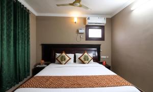 a bedroom with a bed with a green curtain at FabHotel City Inn in Hyderabad