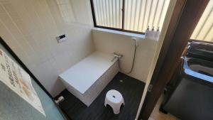 a small bathroom with a toilet and a sink at もくハウス in Kamifukuoka