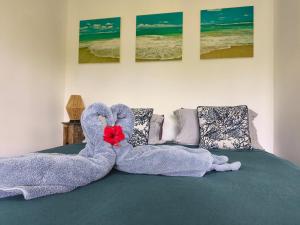 ein Bett mit zwei aus Handtüchern geformten Schwänen in der Unterkunft Te Ava Piti Lodge in Uturoa
