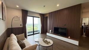 a living room with a couch and a tv at Khách Sạn L'AZUR in Cửa Lô