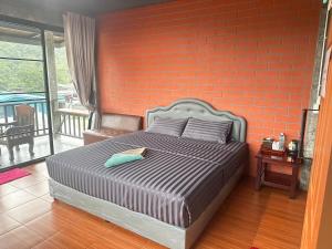 a bedroom with a bed with an orange brick wall at Love Loft Homestay in Ban Pilok Khi +16 photos
