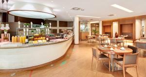 a restaurant with a large table and chairs at Sercotel Valladolid in Valladolid