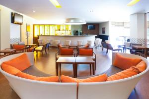 a living room with a couch and tables and chairs at Sercotel Valladolid in Valladolid