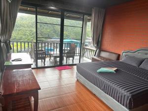 a bedroom with a bed and a balcony with a table at Love Loft Homestay in Ban Pilok Khi