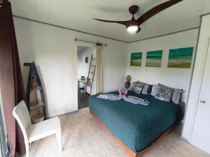 ein Schlafzimmer mit Bett und Deckenventilator in der Unterkunft Te Ava Piti Lodge in Uturoa