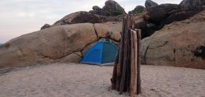 a blue tent on the beach next to a rock at Secret Point Luxury Glamping in Panama