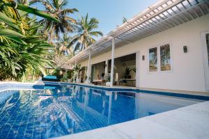 a swimming pool in front of a villa at Luxury 3-Bedroom Villa with Private Pool in Pulukan