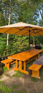 a picnic table with an umbrella on top of it at Glamping Dedovles Vlastný stan in Vyšné Hágy