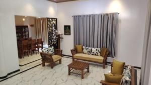 a living room with couches and chairs and a table at CeylonAirbnb in Puttalam