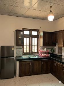 a kitchen with wooden cabinets and a stainless steel refrigerator at CeylonAirbnb in Puttalam